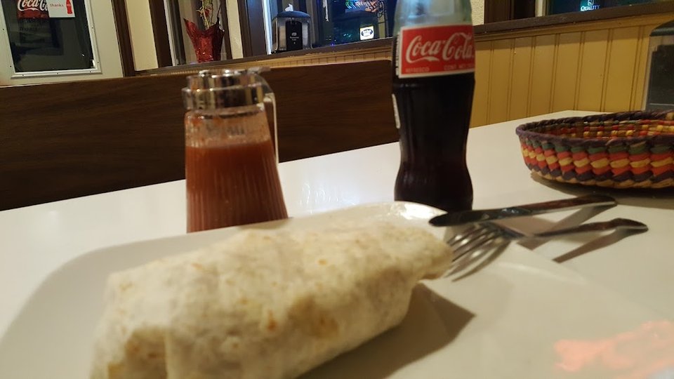 Menu board with specialty plates and burritos.